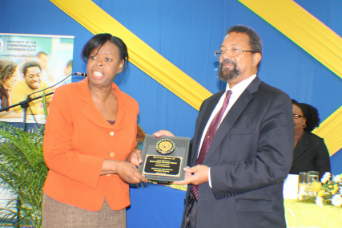 Ms. Eujennie Hewitt (left) presents Prof. Dennis Gayle with a plaque